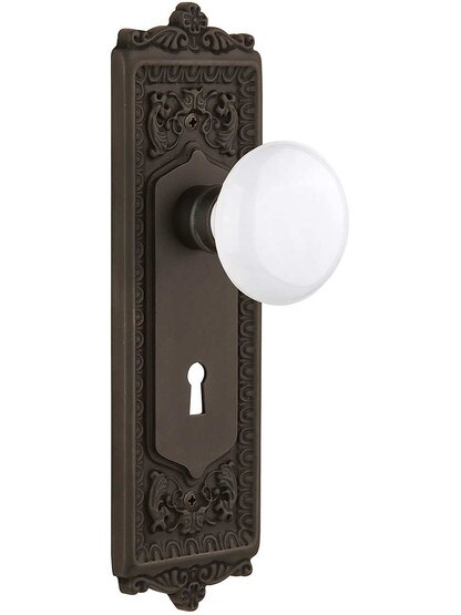 Egg and Dart Door Set with White Porcelain Knobs and Keyhole - 2 3/8 in Oil-Rubbed Bronze.